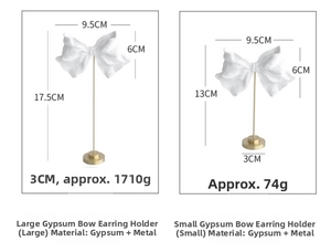 Detailed comparison of large and small white plaster bow earring stands with gold metal rods