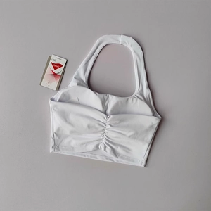 Detail of white ruched halter sports bra featuring high-elasticity Lycra sport fabric tag