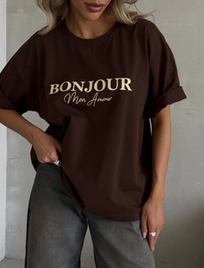 Gros plan du t-shirt oversize marron avec inscription BONJOUR Mon Amour en jaune