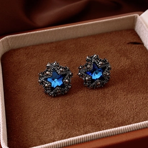 Macro degli orecchini a stella vintage con gemma blu e dettagli in strass pavé