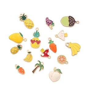 Flat lay of 16 colorful enamel fruit and vegetable charms for DIY jewelry making
