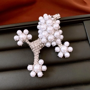 Detail of a luxury poodle brooch with silver base, pearls and sparkling rhinestones
