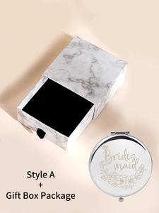 Detail of silver bridesmaid compact mirror with floral design and marble gift box