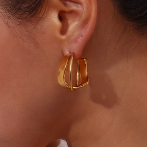 Detailed view of layered 18K gold-plated chunky hoops on ear with polished finish