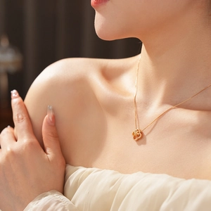 Close-up of 18K gold plated zircon flower pendant necklace worn by a model