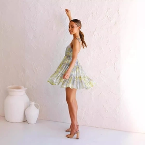 Light green floral sleeveless mini dress with backless design and layered chiffon hem