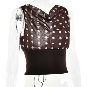 Detailed view of cowl neck polka dot top with elastic brown hem on a white background