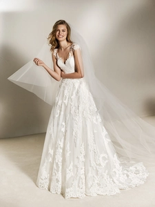 Exquisite white A-line wedding dress featuring delicate lace appliques and a long train