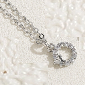Detailed view of silver necklace with butterfly pendant and circular zircon inlay stones