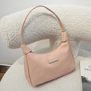 Pink pebbled leather shoulder underarm bag with a gold rectangular metal plaque decor
