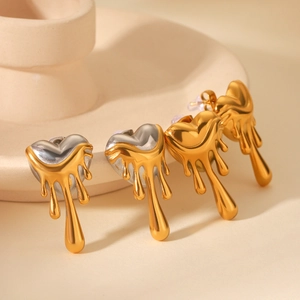 Detailed macro view of two-tone melting lava heart earrings in gold and silver finish