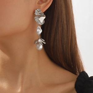 Baroque irregular pearl drop earrings with silver leaf metal petals on a female model