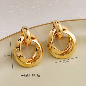 Detailed view of triple intertwined gold hoop earrings on ceramic tray with dimensions