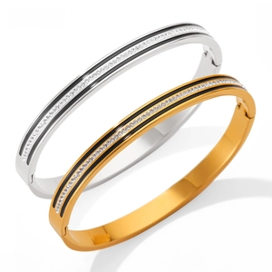 Detail view of interlocking gold and silver stainless steel bangles with crystal inlay
