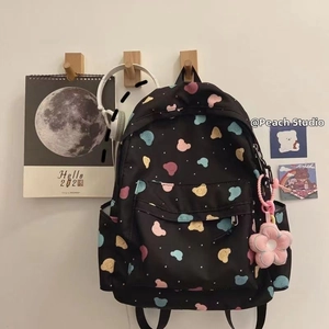 Detail of cute bear printed backpack with a pink flower plush keychain on the front pocket