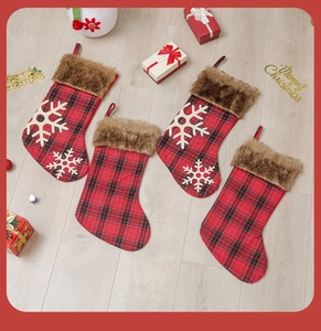Détail de chaussettes de Noël à carreaux rouges et noirs avec bordure en fourrure