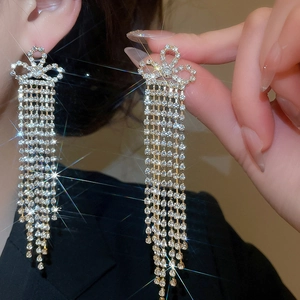 Close-up of sparkling bow tassel earrings with micro-set rhinestones on silver needle