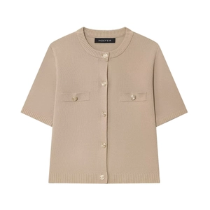 Detail of apricot knit cardigan with gold buttons and faux pockets on white background