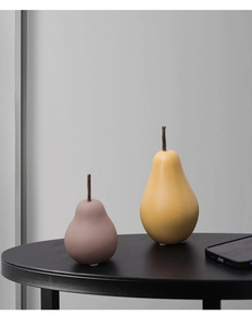 Détail de décoration de poire en céramique moderne en jaune et rose mat sur table