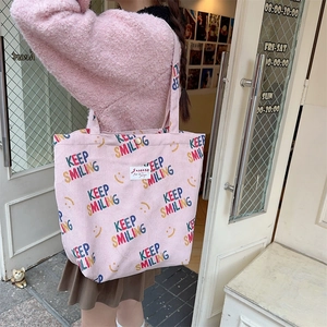 Detail of pink corduroy tote bag featuring Keep Smiling print and magnetic snap button