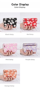 Close-up of five mini daisy coin purses with zippers and metal keyrings in various colors