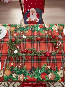 Close-up of red and green plaid Christmas tablecloth and Santa Claus chair covers