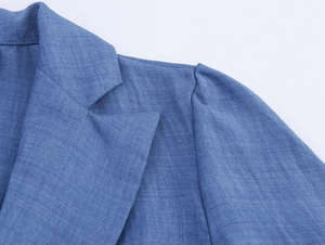 Detail eines eleganten blauen Kleidkragens mit Spitzennähten und Webstruktur