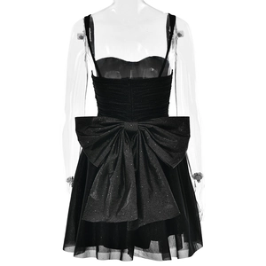 Detail of a black mini dress featuring a large sparkling bow and pleated tulle skirt