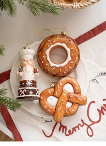 Gingerbread style Christmas ornaments including donut and nutcracker on a white plate