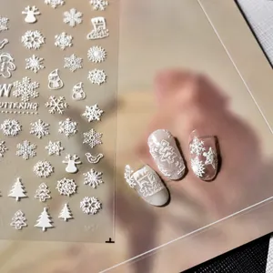 Detailed 3D embossed white snowflake and Christmas tree nail art stickers on a sheet