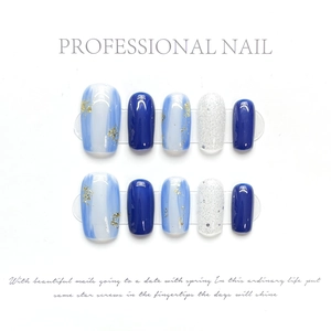 Detail von 10 handgefertigten blauen Ombre-Klebe-Nägeln mit Goldfolie und Glitzer