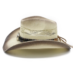 Vue détaillée d'un chapeau de cow-boy en paille avec bande ethnique et breloque taureau