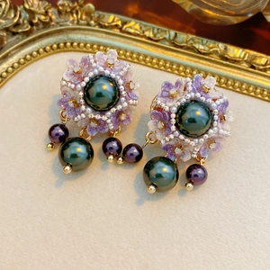 Detail of vintage flower earrings with peacock green pearls and resin petals