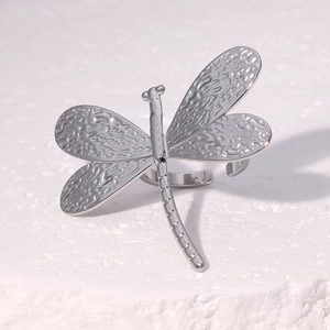 Macro shot of silver dragonfly ring showing hammered wings and adjustable band details