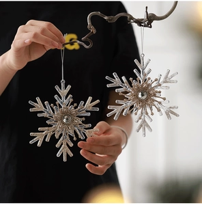 Detail of clear acrylic snowflake ornaments with champagne gold glitter and crystal centers