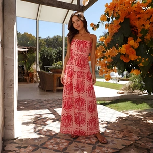 Détail de la robe d'été rose avec imprimés palmier rouge et décolleté licou pour la plage