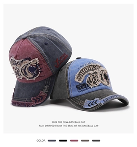 Close-up of distressed denim baseball caps with vintage shark embroidery and patch details