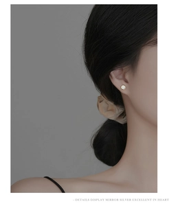 Close-up of elegant gold plated silver round stud earring with clear crystal on model