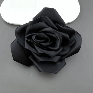 Top view of a 11cm handmade black fabric camellia rose flower with layered silk texture