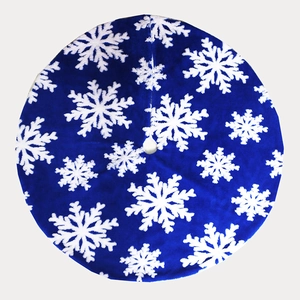 Detail of dark blue plush Christmas tree skirt featuring white snowflake patterns