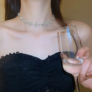 Close-up of sparkling diamond teardrop collar necklace worn on a model's neck