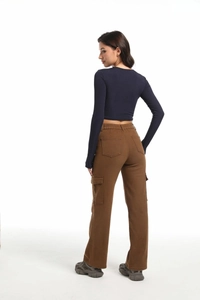 Rear view of high-waist brown multi-pocket cargo pants paired with a dark blue crop top