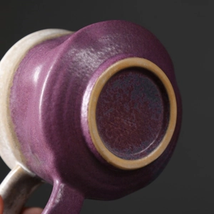 Detailed close-up of handmade purple ceramic mug base showing rustic stoneware texture