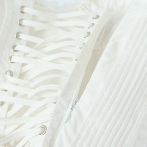 Detailed macro view of white bodice with corset lacing and fine vertical pleated fabric