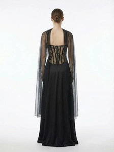 Detail of black lace corset back on evening dress with long sheer tulle cape