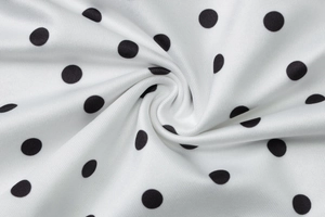 Macro shot of high-quality white textile fabric with classic black polka dot print details