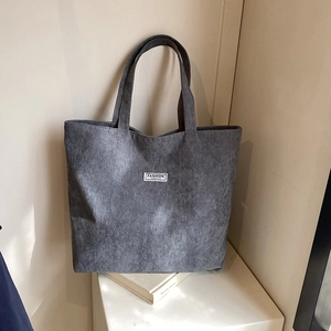Detail of grey corduroy tote bag showing vertical texture and Fashion Instinct label