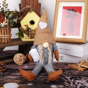 Knitted Christmas gnome decoration with long legs and a camel pointed heart hat