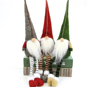 Three plush Christmas gnomes set with striped long legs and pointed hats on white background