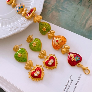 Detailed close-up of vintage heart enamel earrings and bracelet set in gold finish
